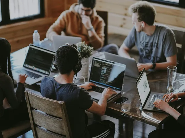 Equipo de ingeniería trabajando en conjunto sobre laptops.